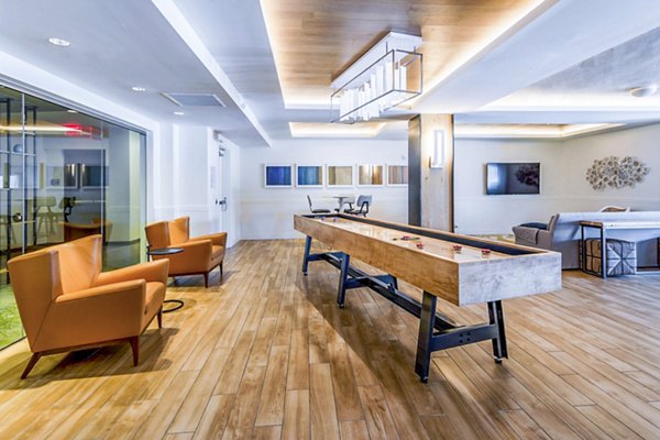 Clubhouse game room with pool table and seating at VY Reston Heights Apartments, ideal for social gatherings and leisure activities