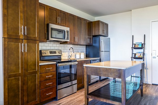 Modern kitchen with stainless steel appliances and granite countertops in VY Reston Heights Apartments