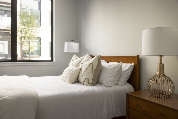 Bluff at Boulder Commons: Cozy bedroom with modern design elements and ambient lighting in luxury Greystar apartments