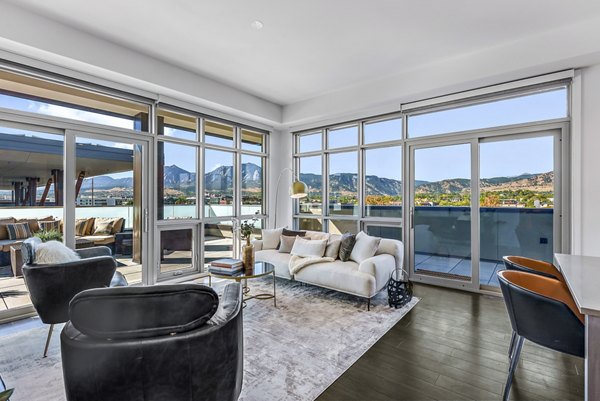 Spacious living room with modern decor and large windows at Bluff at Boulder Commons Apartments