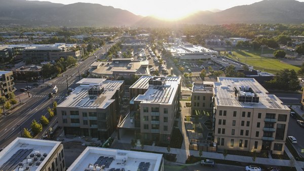 Aerial view of luxury apartments with green landscaping and pathways surrounding the property