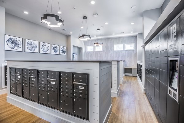 Allora Alamo Heights: Modern clubhouse mail room with organized mailboxes and seating area