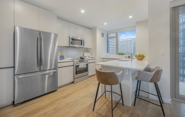 Modern kitchen with sleek cabinetry and stainless appliances in The Alyx Apartments