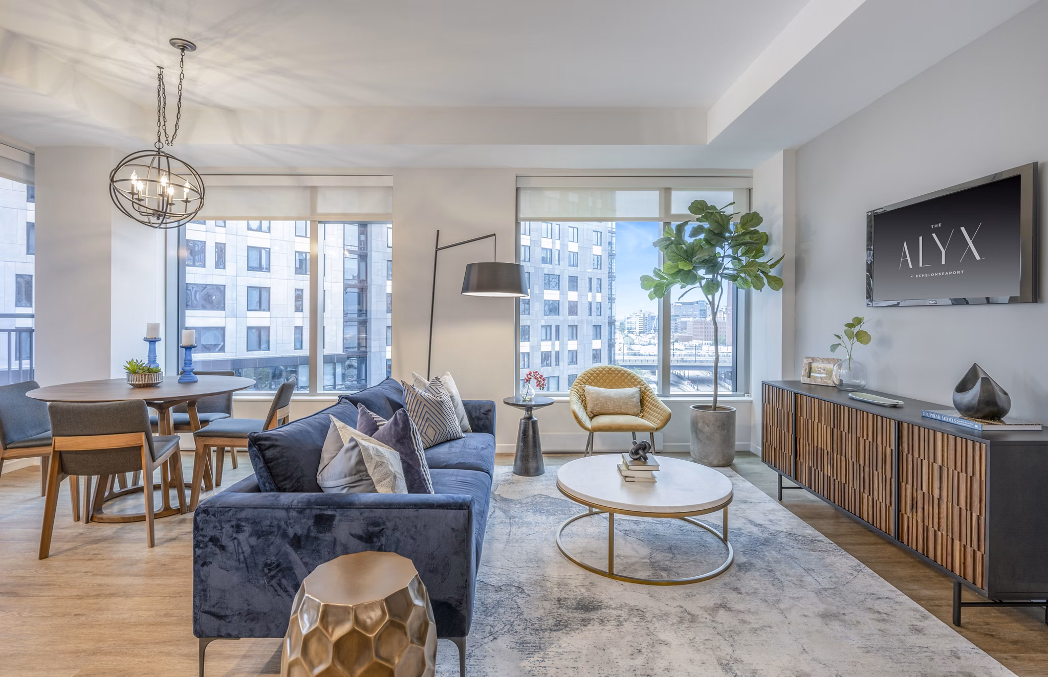 Contemporary living room with sleek furnishings at The Alyx Apartments, featuring expansive window views