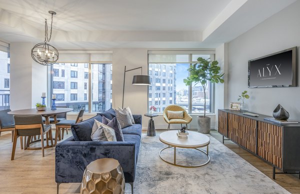 Contemporary living room with sleek furnishings at The Alyx Apartments, featuring expansive window views