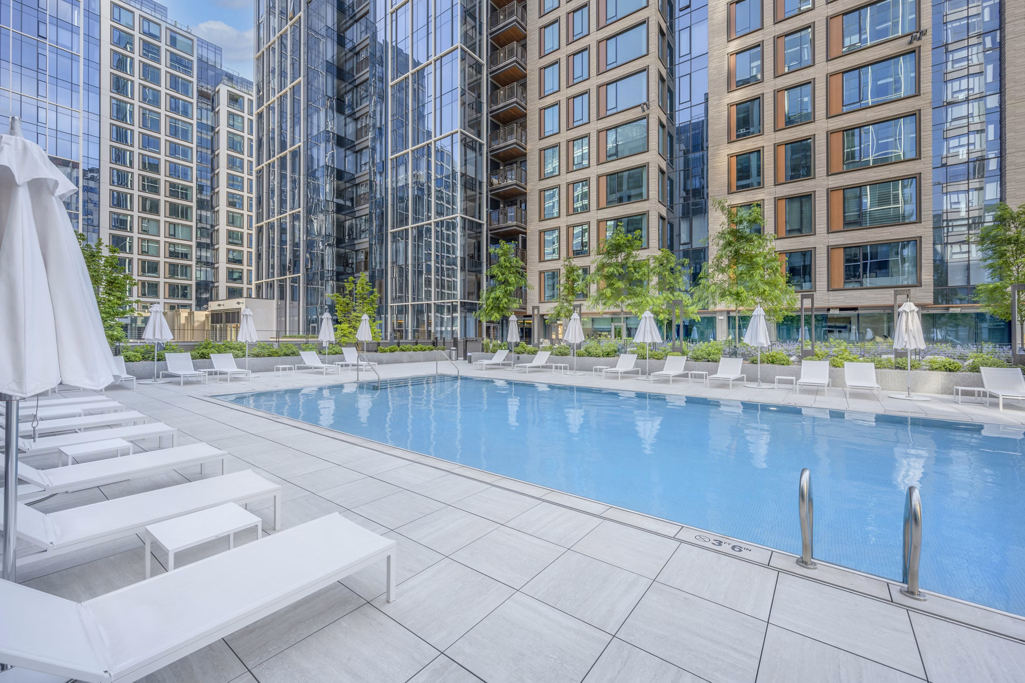 Elegant pool area with sun loungers at The Alyx Apartments, luxury living in the city