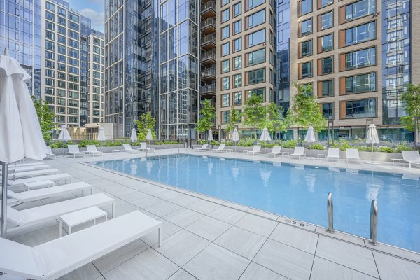 Elegant pool area with sun loungers at The Alyx Apartments, luxury living in the city
