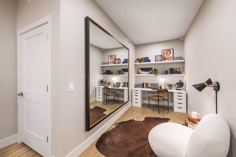 Home office with modern decor at Sunela Apartments: Cozy workspace featuring sleek desk and large window for natural light in a luxury San Francisco apartment