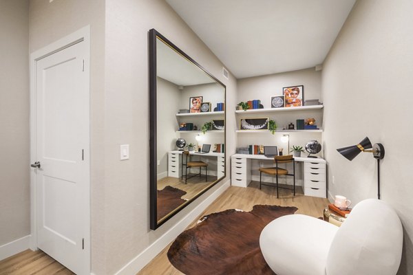 Home office with modern decor at Sunela Apartments: Cozy workspace featuring sleek desk and large window for natural light in a luxury San Francisco apartment