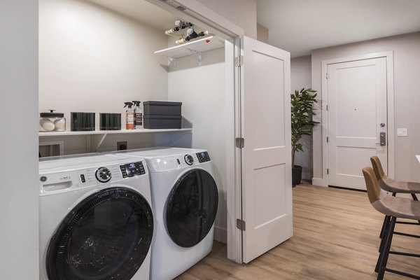 Laundry room with modern appliances at Sunela Apartments