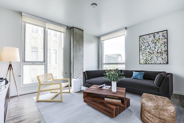 Spacious living room with modern decor at Vance Apartments with large windows allowing natural light