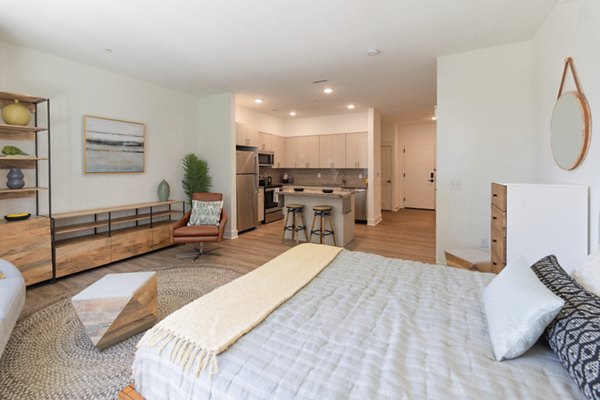 Cozy bedroom with modern furnishings at Harrison Yards Apartments, featuring large windows and ample storage options Perfect for urban living