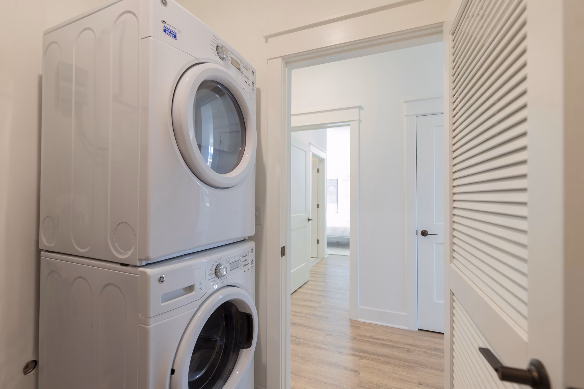 Laundry room with modern machines at Harrison Yards Apartments offering convenience to residents