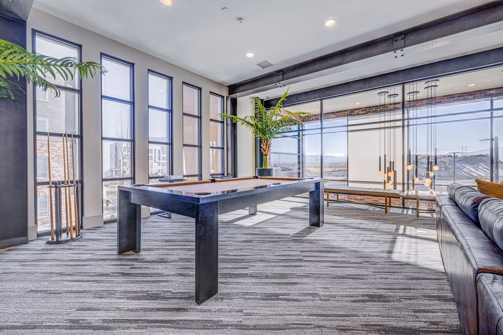 Clubhouse game room featuring a billiards table and lounge seating at Reveal Apartments luxury community