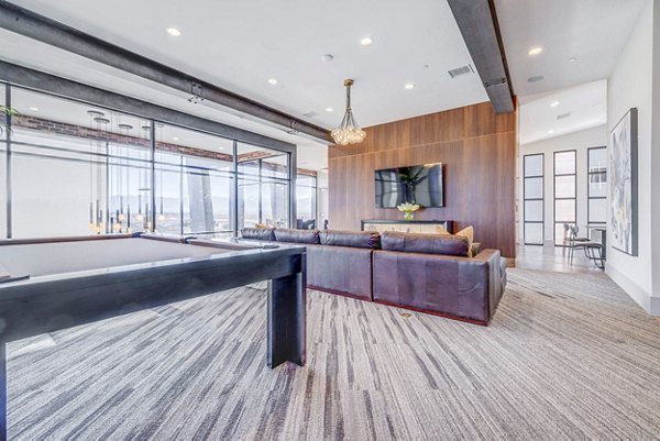 Modern clubhouse game room featuring pool table and lounge seating at Reveal Apartments
