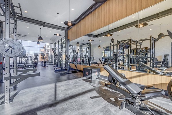 Modern fitness center with state-of-the-art equipment at Reveal Apartments, designed for luxury living and wellness