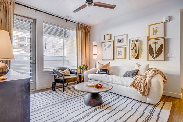 Cozy living room with modern decor at Reveal Apartments, featuring comfortable seating and contemporary design