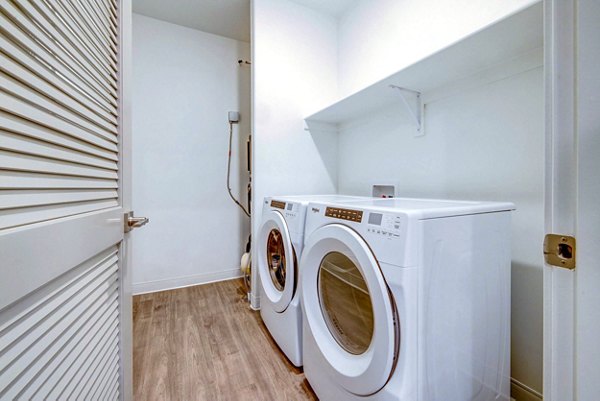 Laundry room featuring modern appliances in Reveal Apartments
