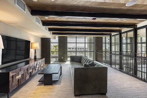 Modern clubhouse with stylish decor at Hollywood Park Apartments, featuring cozy seating and vibrant lighting