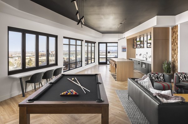 Clubhouse game room with billiards and seating area at Braxton Apartments