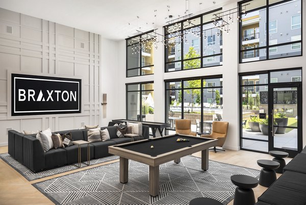 Clubhouse game room with billiards and lounge area at Braxton Apartments in a luxury community