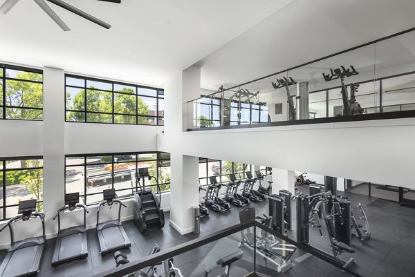 State-of-the-art fitness center with cardio machines and weights at Braxton Apartments