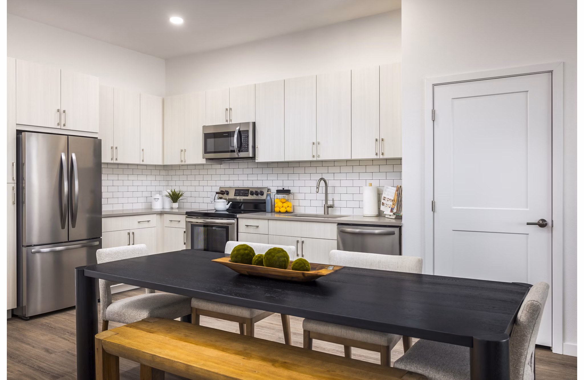 Open-concept kitchen and dining room with modern appliances in Braxton Apartments, a luxury community by Greystar