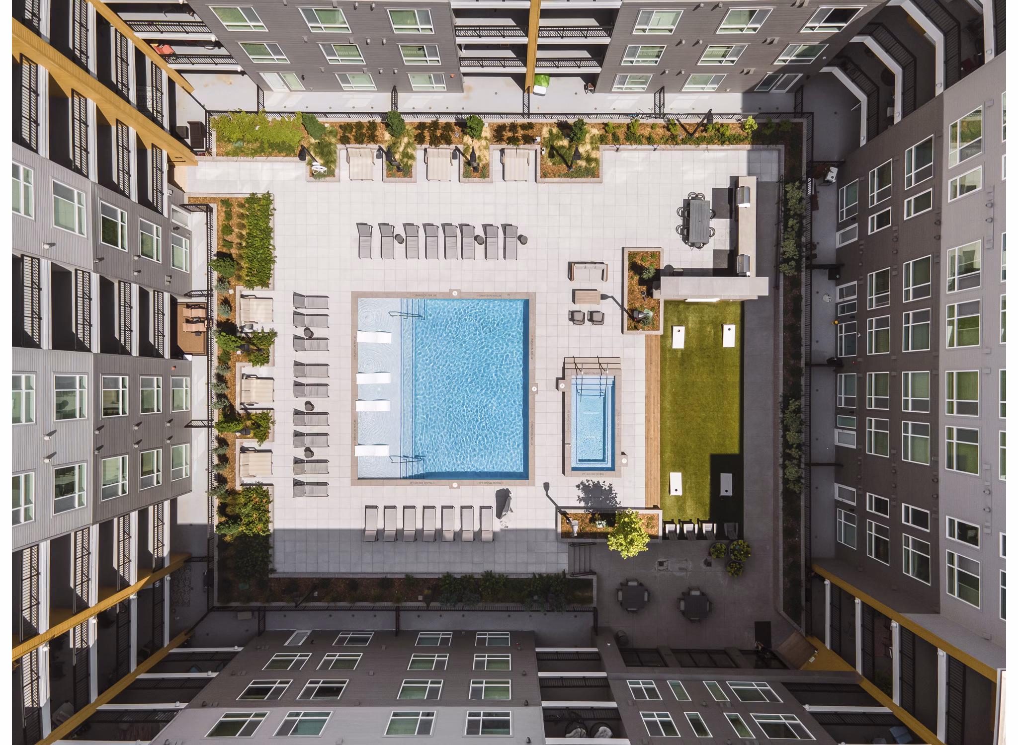 Relaxing outdoor pool at Braxton Apartments with luxurious poolside seating and lush landscaping