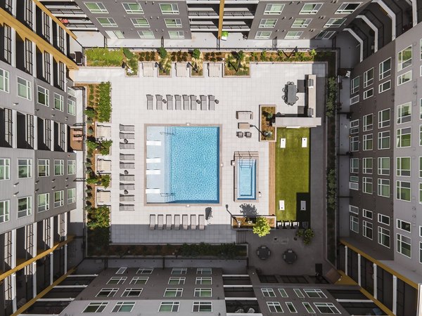 Relaxing outdoor pool at Braxton Apartments with luxurious poolside seating and lush landscaping