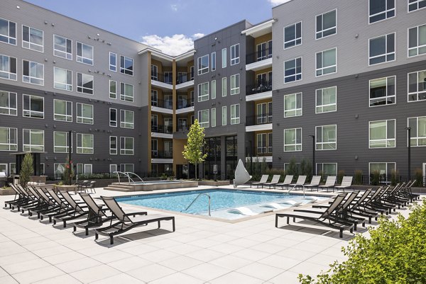 Braxton Apartments: Spacious outdoor pool area with lounging spaces and landscaping for relaxation and leisure
