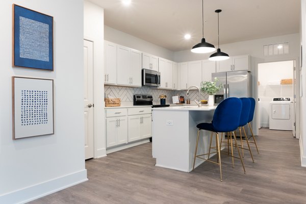 Modern kitchen featuring stainless steel appliances and granite countertops at Capriana Apartments