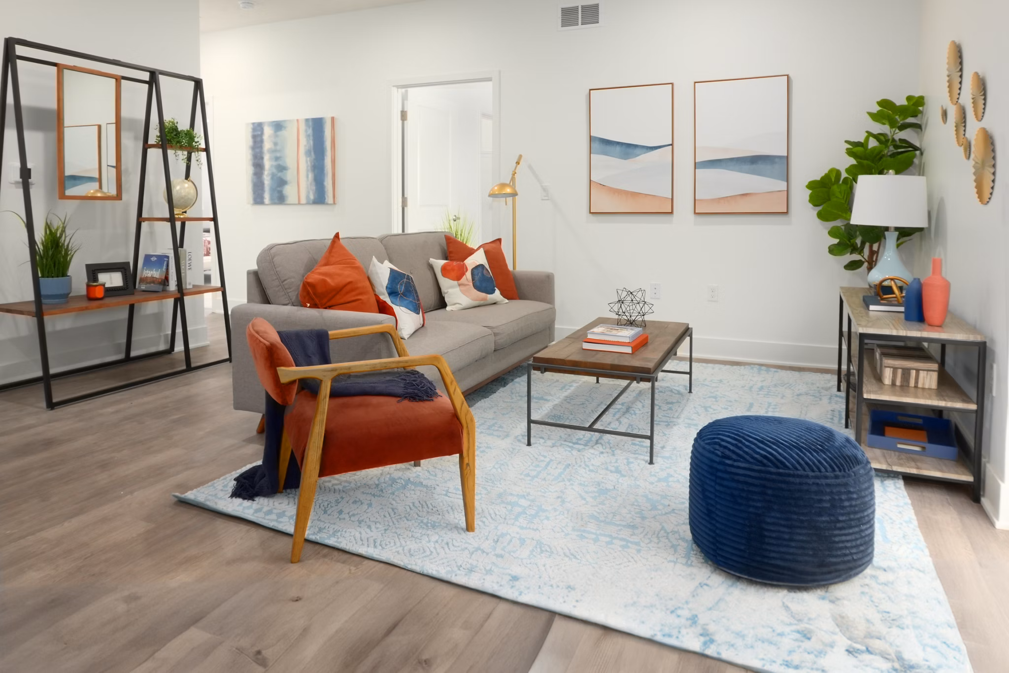 Cozy living room with modern decor and large windows at Capriana Apartments, offering contemporary comfort and style in a luxurious setting