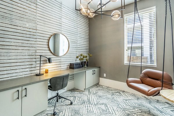 Clubhouse business center with modern workstations at The Chloe Leander Apartments, offering a productive environment