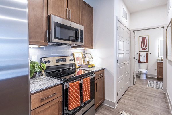 Modern kitchen with stainless steel appliances at The Chloe Leander Apartments