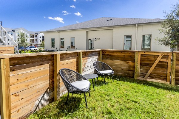 Patio with comfortable seating at The Chloe Leander Apartments, ideal for outdoor relaxation and social gatherings