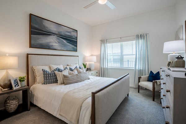 Modern bedroom with elegant decor at Eden Heritage Lakes Apartments featuring ample natural light