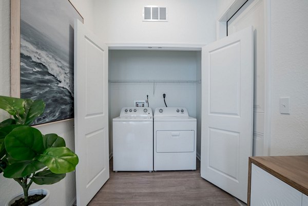 Laundry room with high-efficiency washers and dryers at Eden Heritage Lakes Apartments
