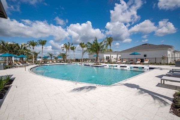 Resort-style pool surrounded by lush landscaping at Bay Court in Eden Heritage Lakes Apartments