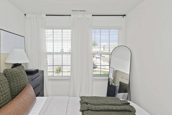 Cozy bedroom featuring modern furnishings and elegant design at Affinity at Hudson Apartments