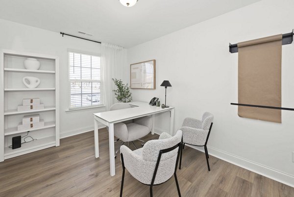 Home office with ergonomic desk and large windows in Affinity at Hudson Apartments