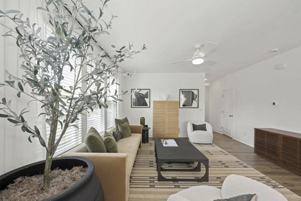 Modern living room with stylish furnishings featuring wood flooring at Affinity at Hudson Apartments, luxury apartment community