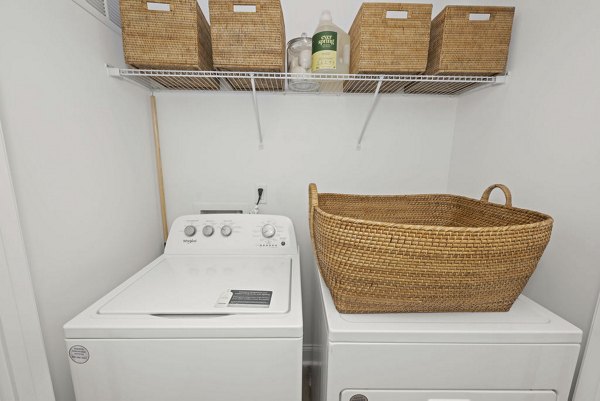 Laundry room featuring modern appliances at Affinity at Hudson Apartments