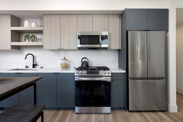 Modern kitchen with stainless steel appliances at The Charlie WeHo Apartments, luxury living space in West Hollywood