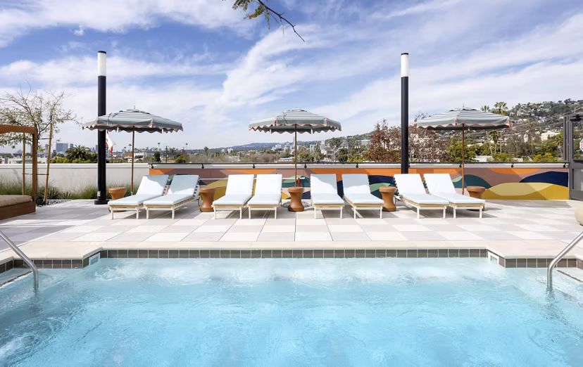 Infinity-edge pool surrounded by cabanas at The Charlie WeHo Apartments