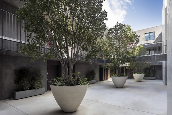 The Charlie WeHo Apartments: Tranquil courtyard with lush landscaping and seating in luxury West Hollywood apartments