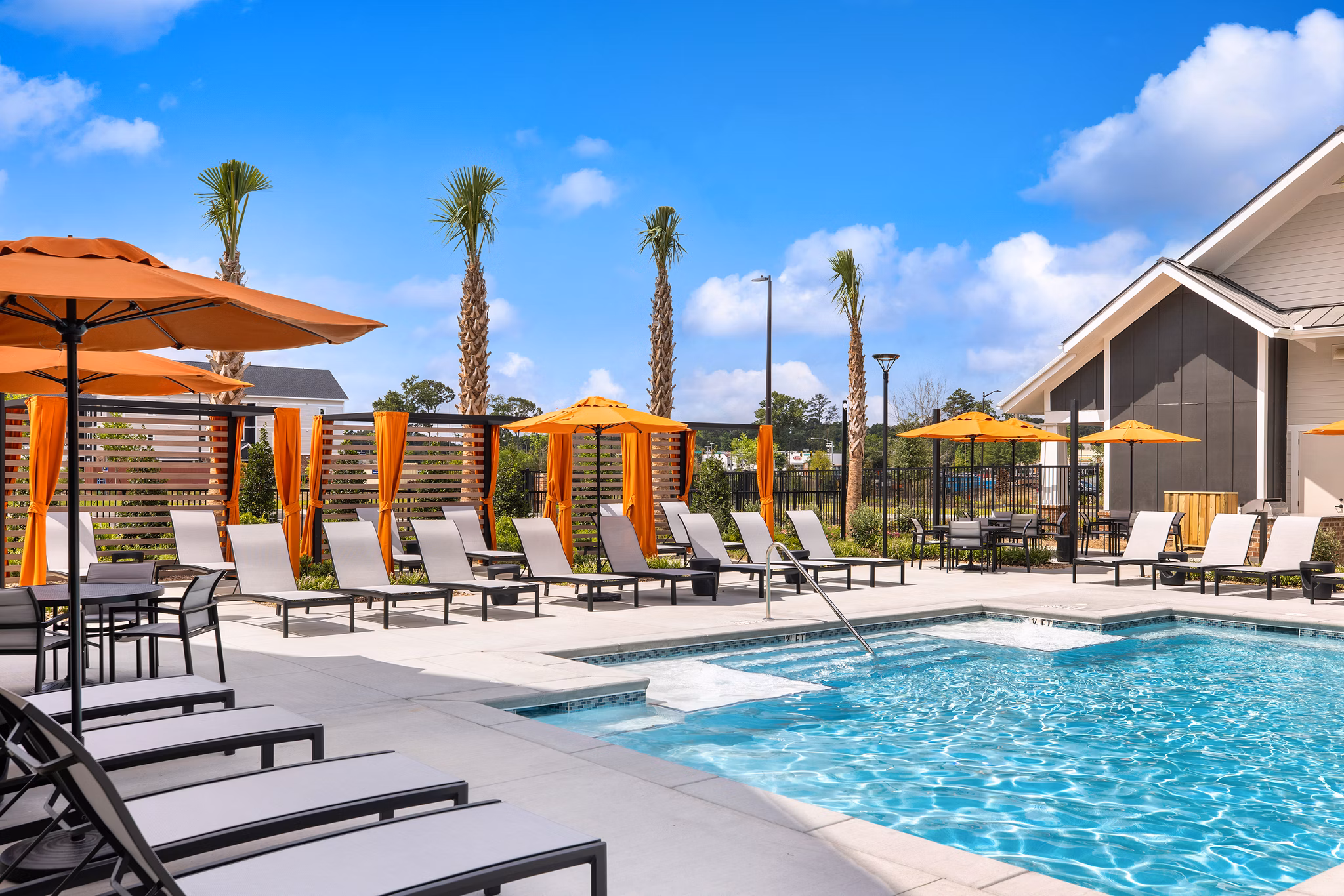 Outdoor pool with lounge chairs and lush landscaping at Riverchase Vista Apartments offering luxury living experiences