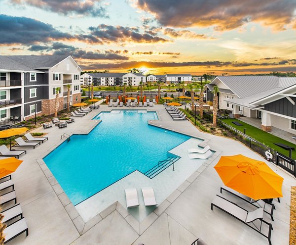 Resort-style pool oasis at Riverchase Vista Apartments with loungers and lush landscaping