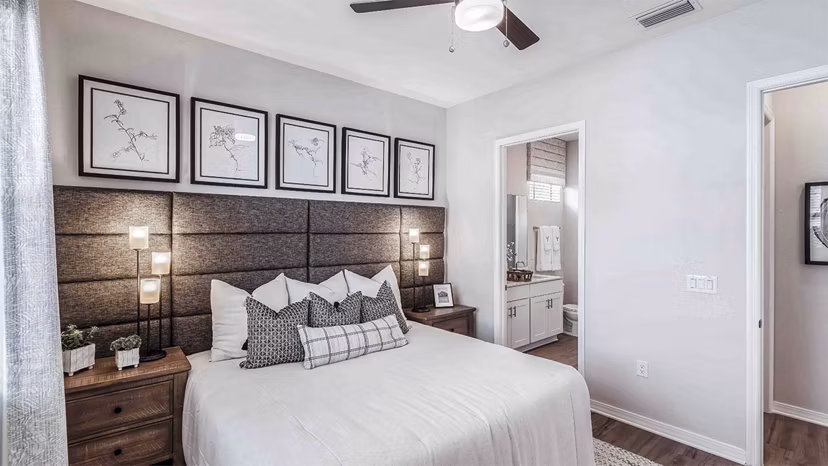 Inviting modern bedroom with large window and cozy furnishings at Yardly Artisan Lakes Homes