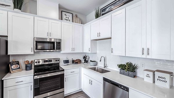 Modern kitchen featuring stainless steel appliances and granite countertops at Yardly Artisan Lakes Homes