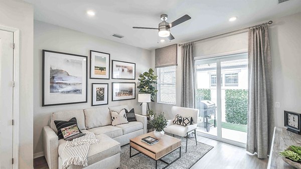 Living room with stylish decor and natural light at Yardly Artisan Lakes Homes